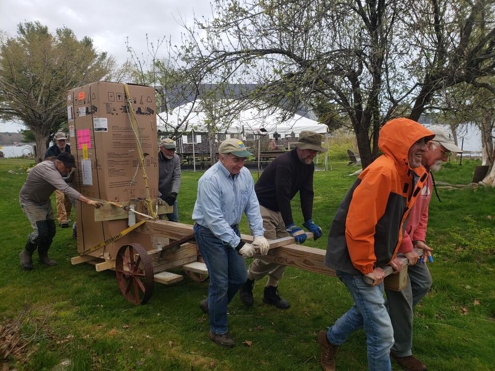 FOHI volunteers move a heat pump water heater to the Crows Nest 